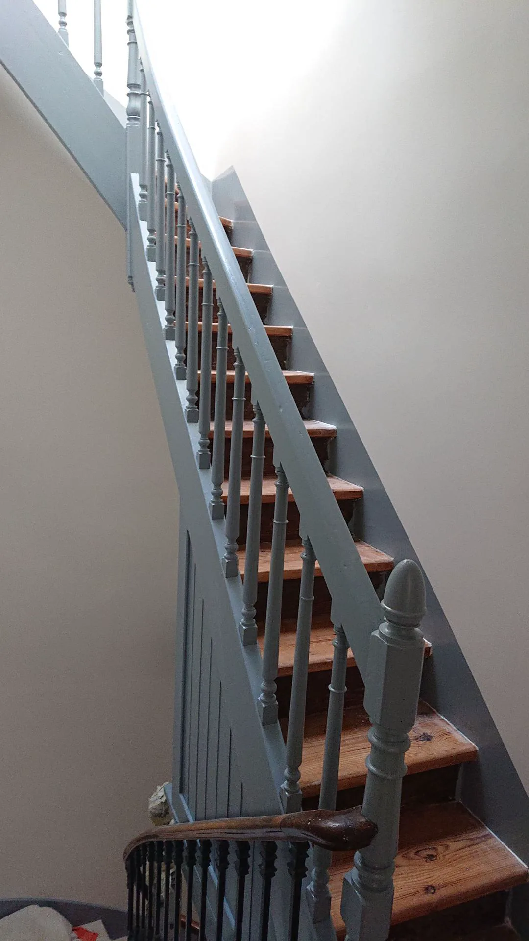Escalier intérieur avec murs fraîchement peints et garde-corps bleu-gris
