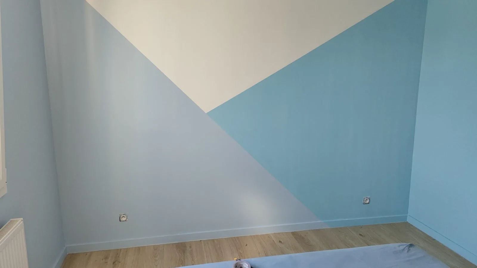 Mur de chambre peint en deux teintes, bleu doux et blanc cassé